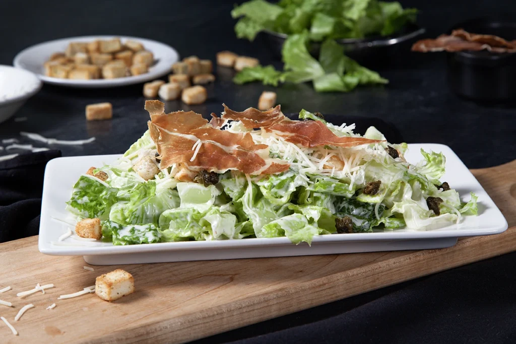 Salade César avec laitue romaine, croûtons, bacon et parmesan servie chez PACINI