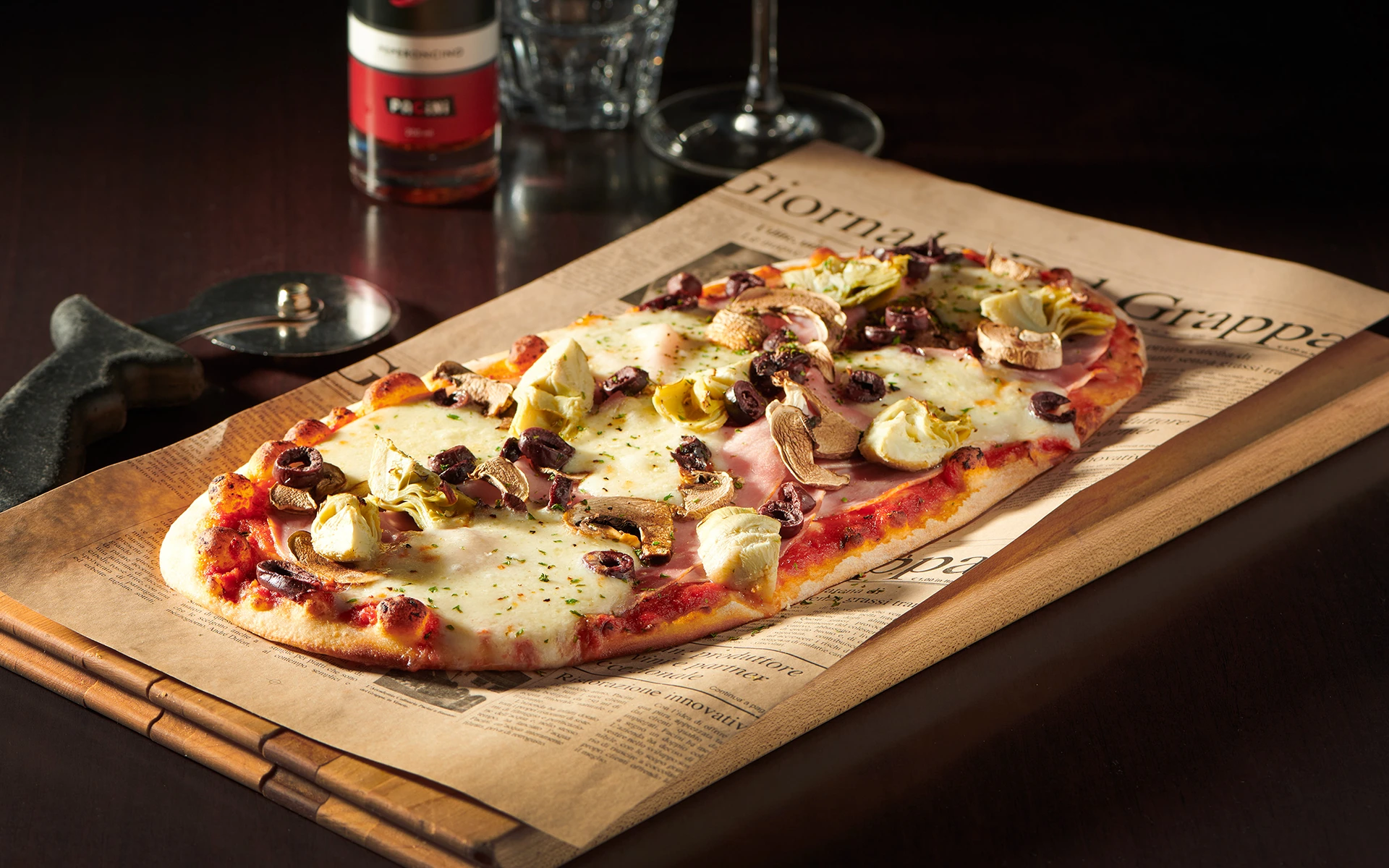 Pizza Capricciosa garnie de champignons, artichauts, jambon et fromage