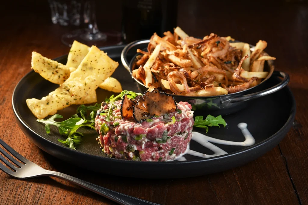 Tartare de bœuf coupé au couteau et assaisonné avec précision