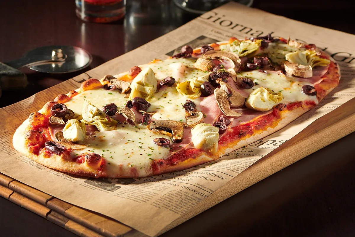 Pizza Capricciosa garnie de champignons, artichauts, jambon et fromage